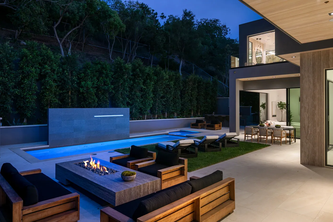 Fire pit lounge beside the pool at night