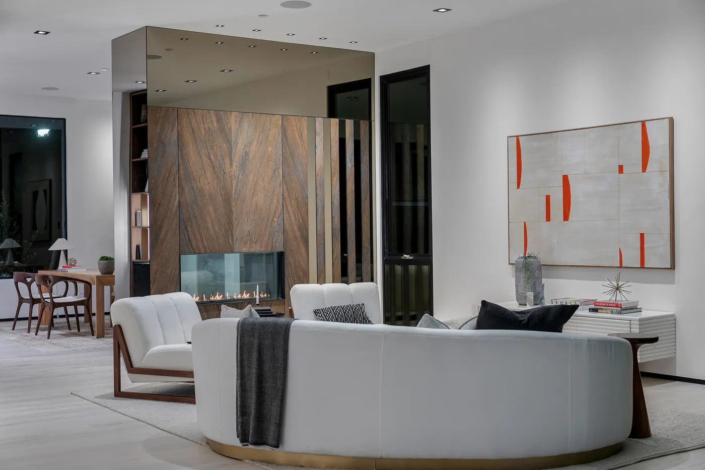 Living room with a curved sofa and fireplace wall