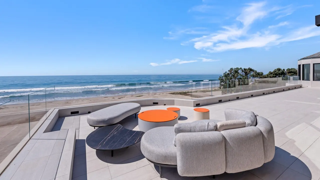 The upper terrace lounge with curved outdoor seating above the beach