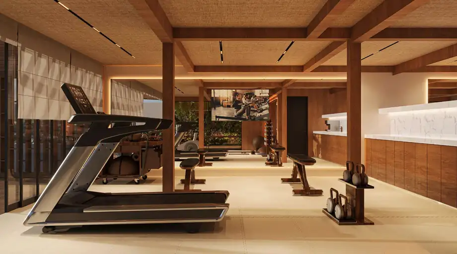 A gym with a timber beamed ceiling, full-height glazing and equipment along a mirrored wall