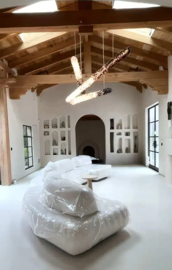 A bedroom with panelled walls, integrated lighting and a upholstered headboard
