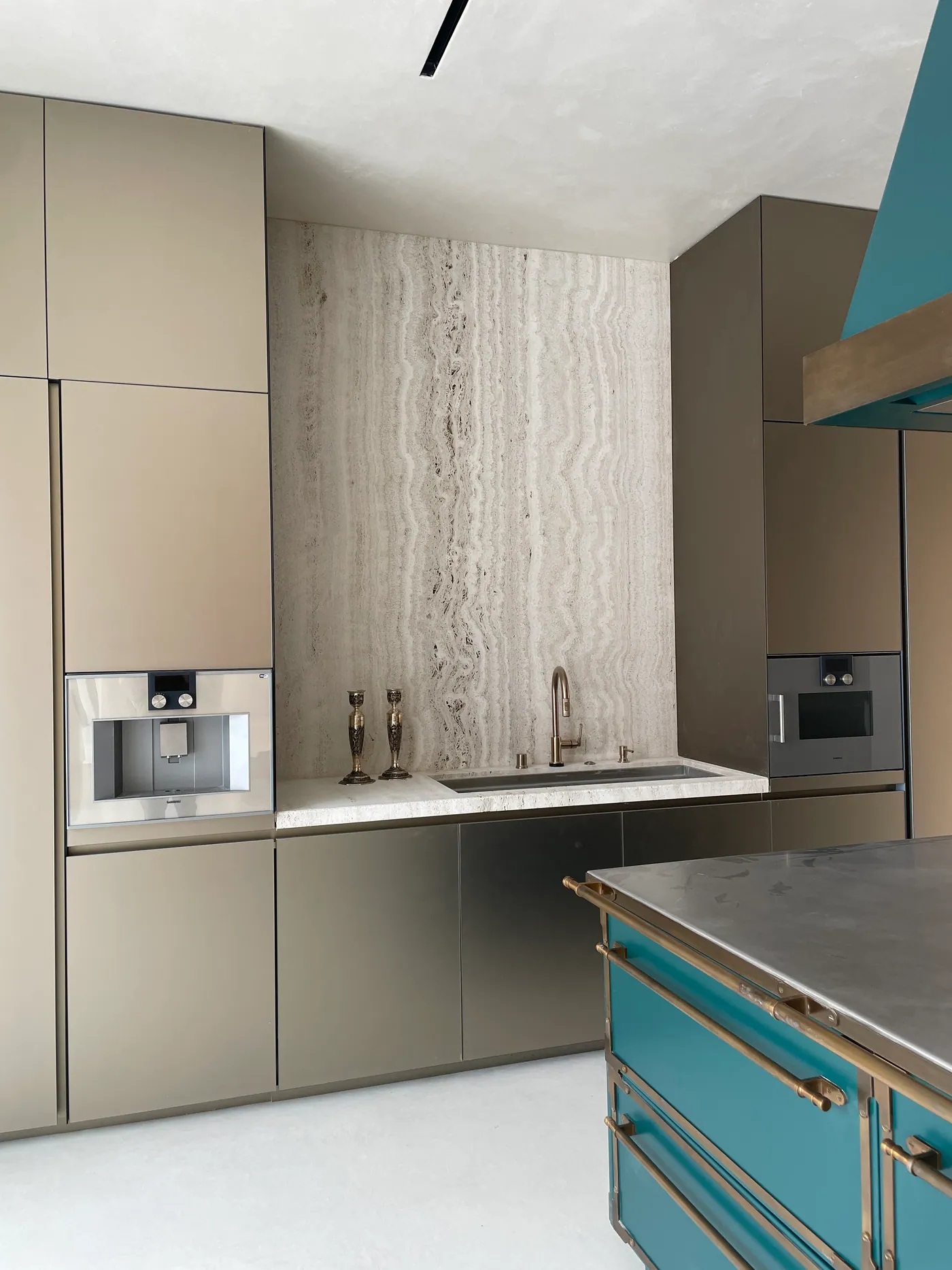 Kitchen in bronze and stone with an emerald range