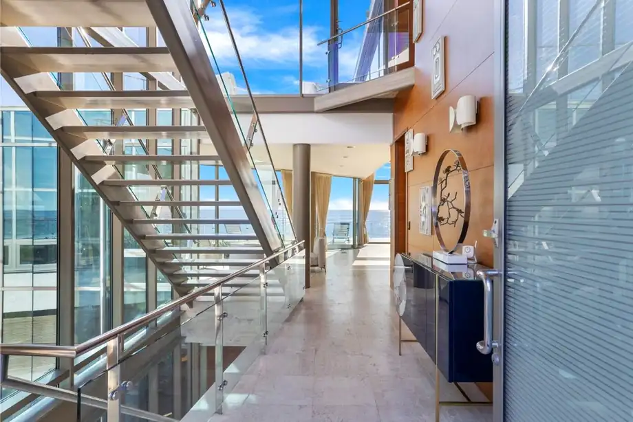 A dining area beside full-height glazing with the ocean beyond