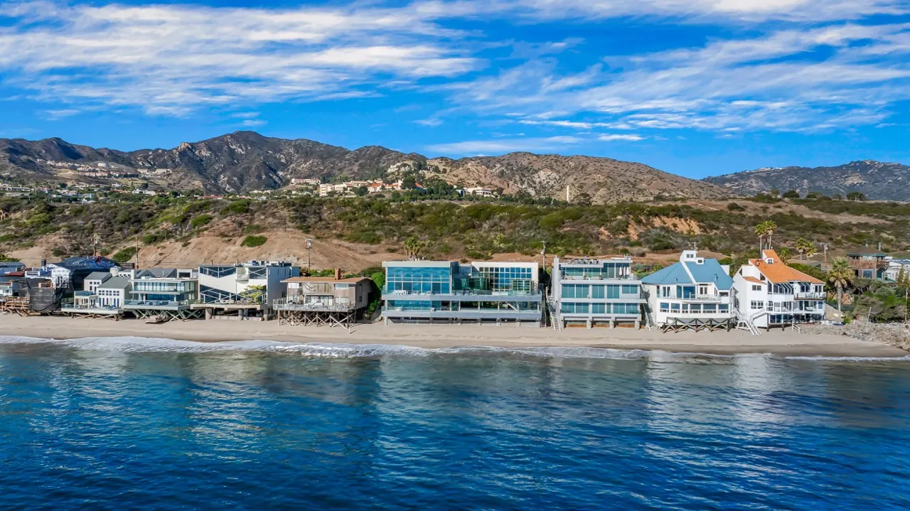 Malibu Road from the water: the glass house among its beach-front neighbours below the mountains