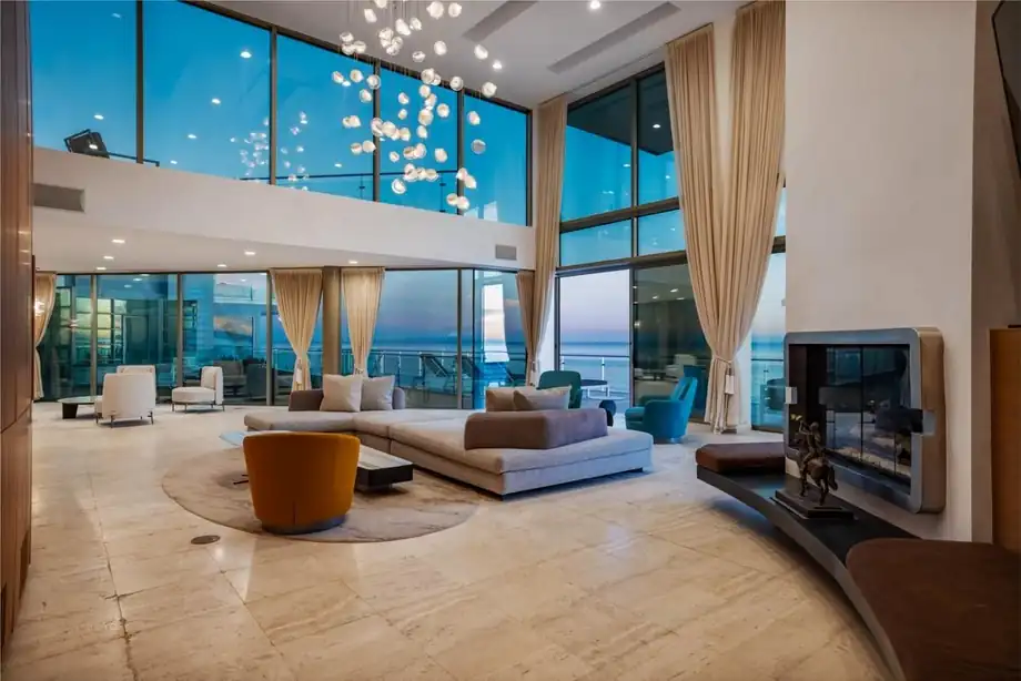 A double-height oceanfront living room with floor-to-ceiling glazing
