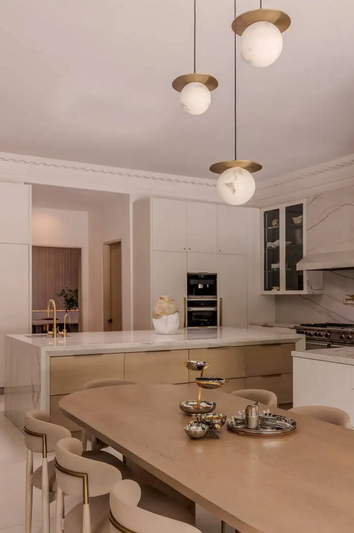 A breakfast counter with pendant lights, a stone top and upholstered stools