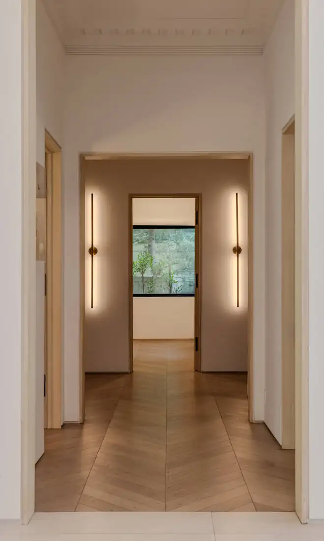 A long enfilade of squared openings running to a window at the far end