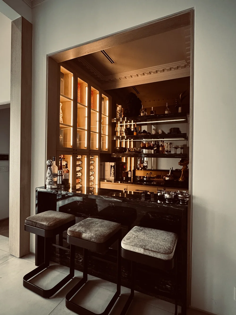 Bar counter with stools beneath the lit display