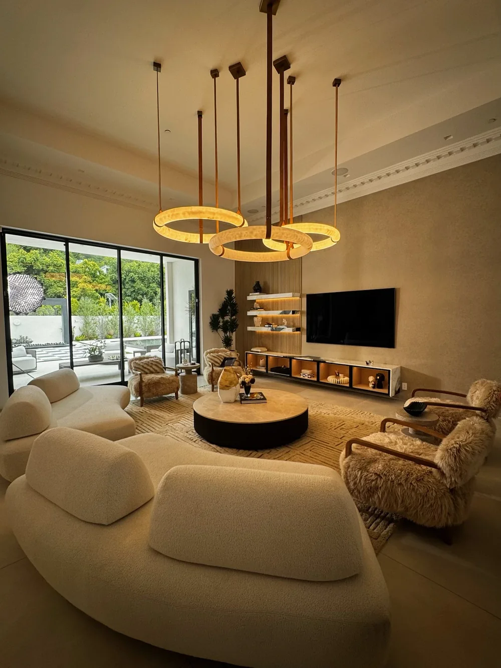 Living room seating around a round table, garden doors beyond