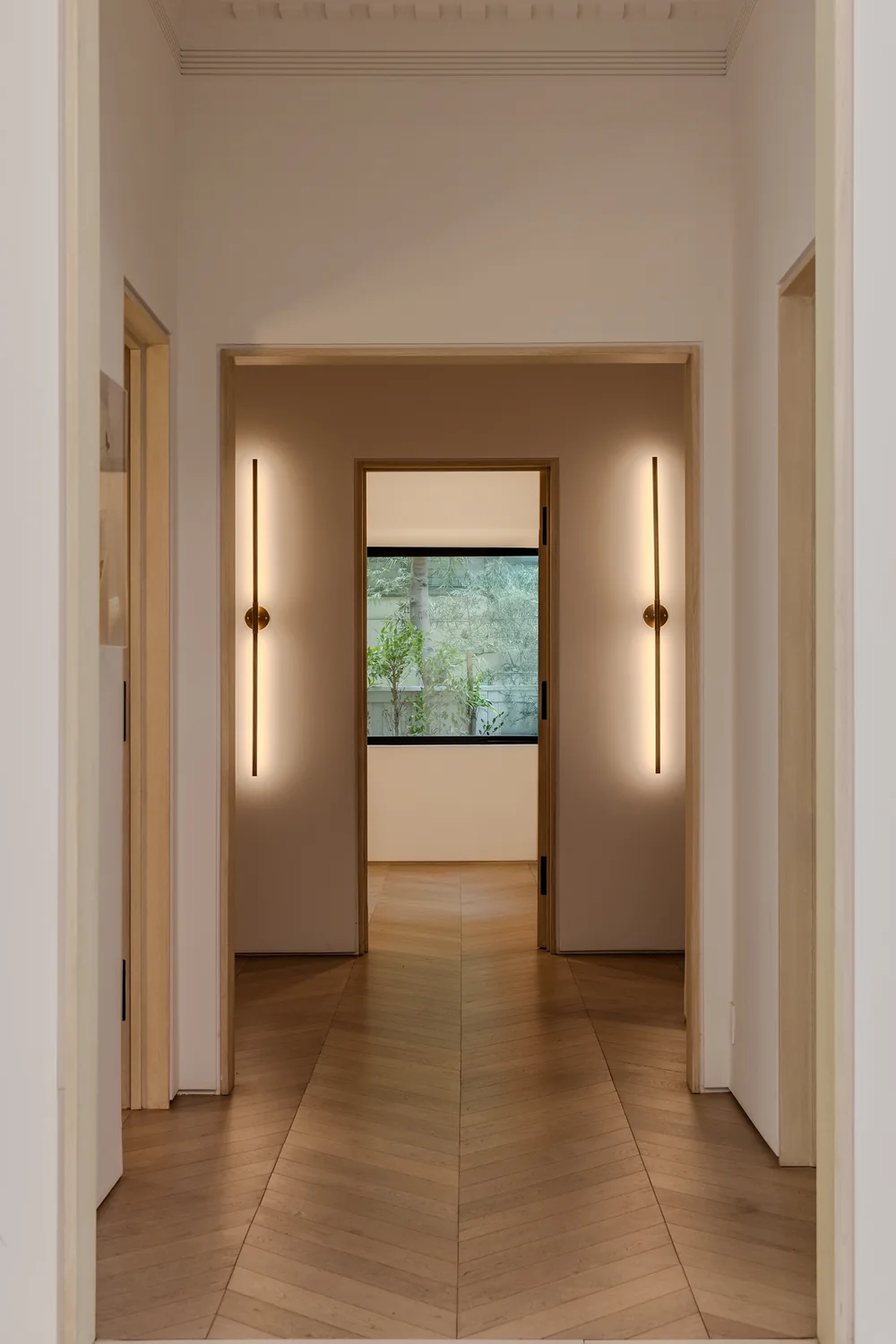 Hallway with chevron oak floor and squared openings