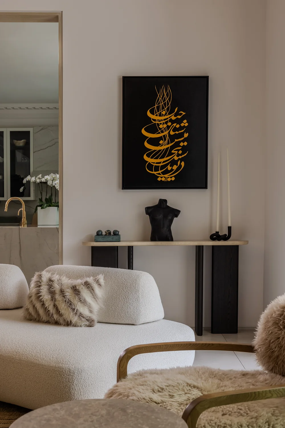 Living room corner with calligraphy artwork and curved sofa