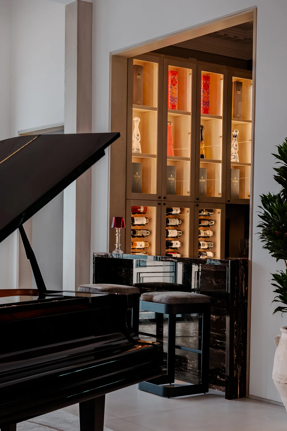 Bar with backlit display cabinet beside the piano
