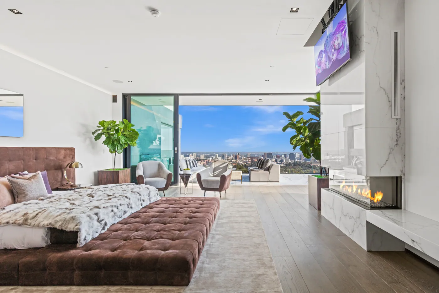 Primary bedroom with fireplace and terrace view