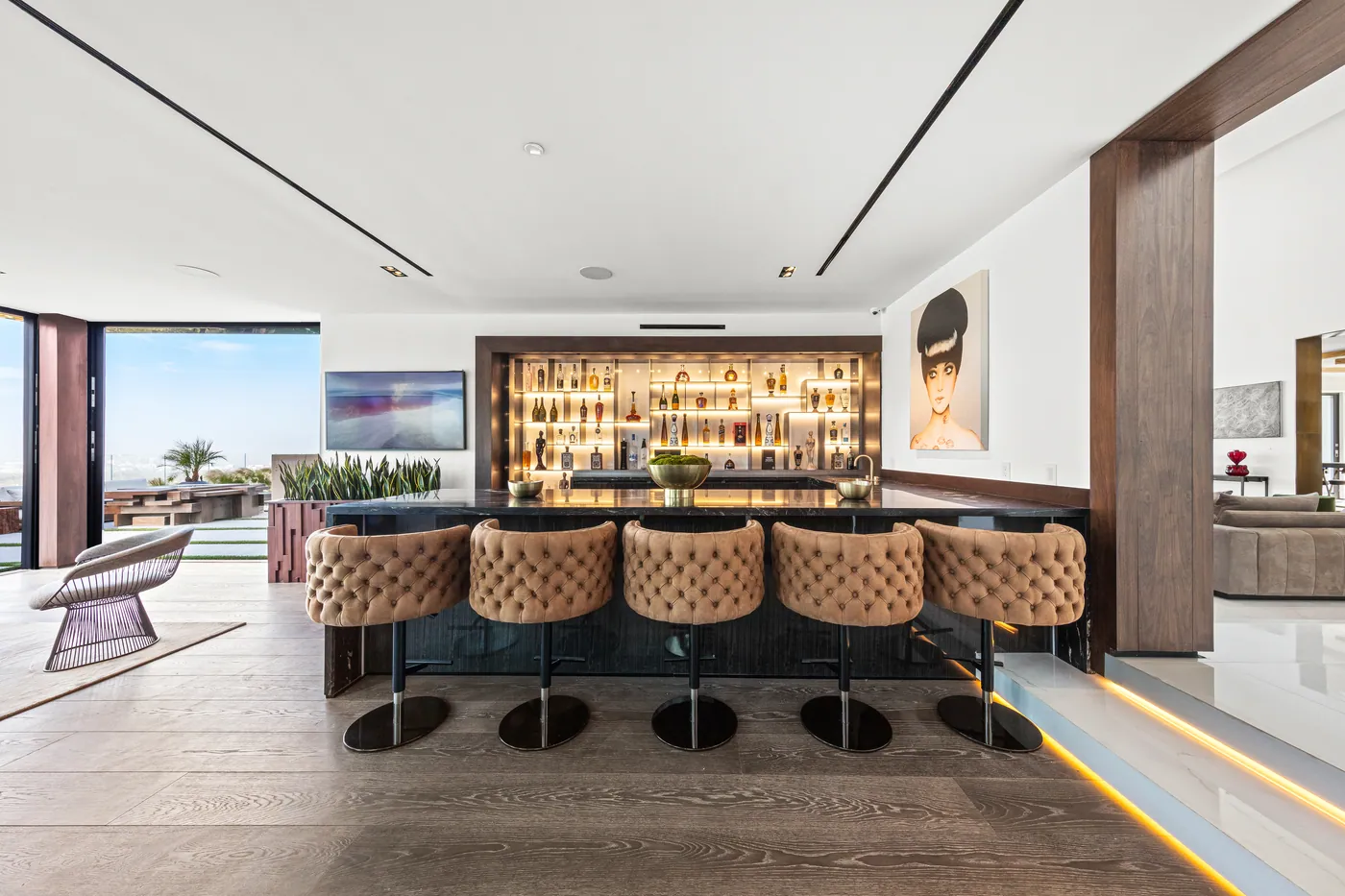 Bar with tufted leather stools and a city view