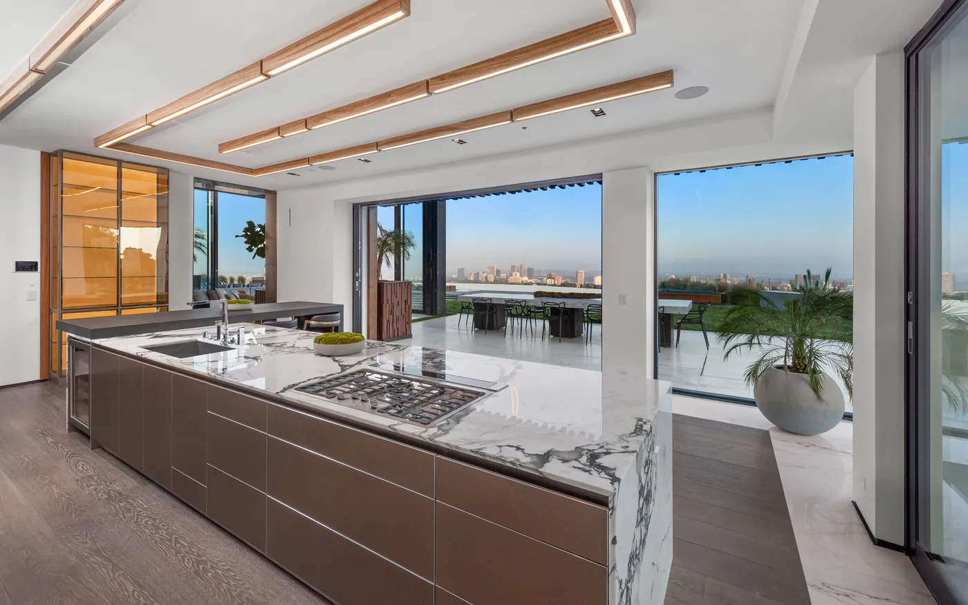 Kitchen with a long marble island and city view